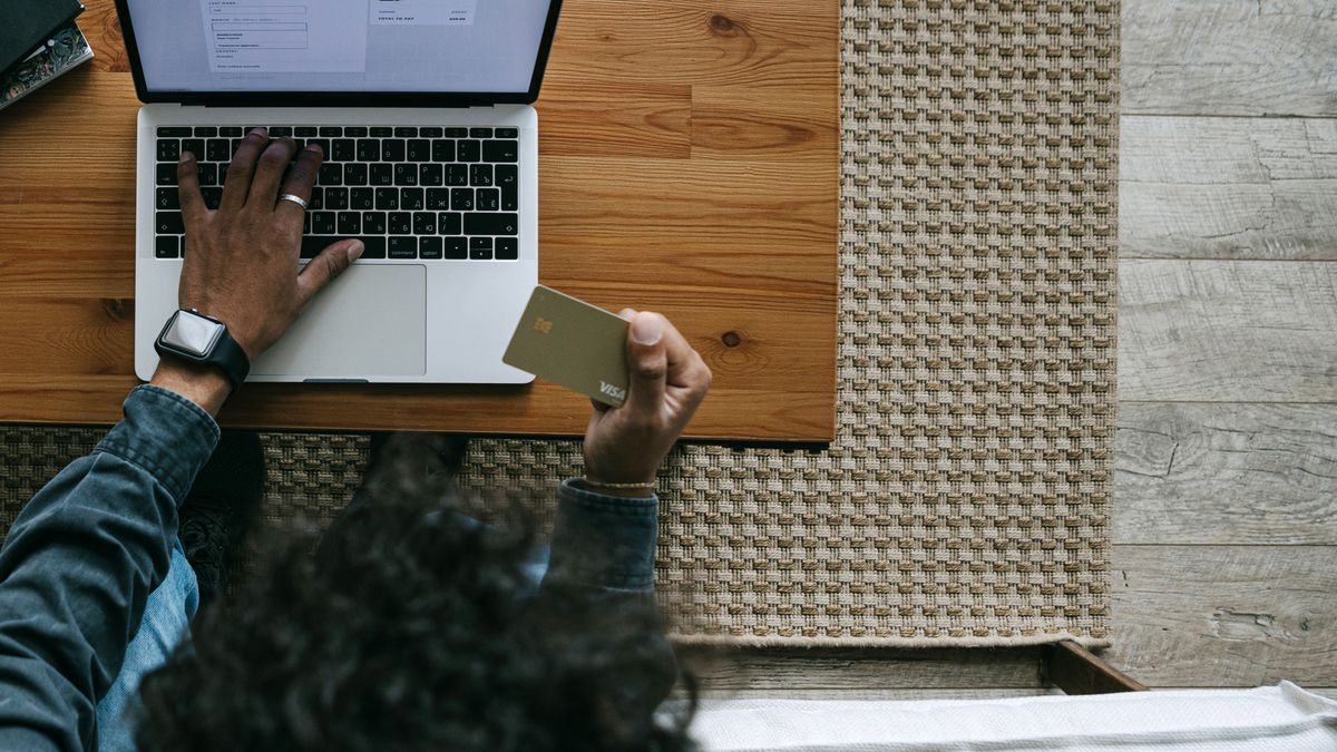 Overhead view of a person using a laptop and credit card for online shopping
