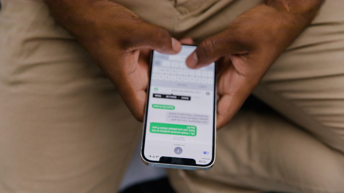 Close-up view of hands texting on a smartphone, focusing on the screen displaying messages