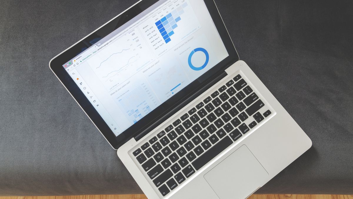 Overhead view of a laptop showing data visualizations and charts on its screen