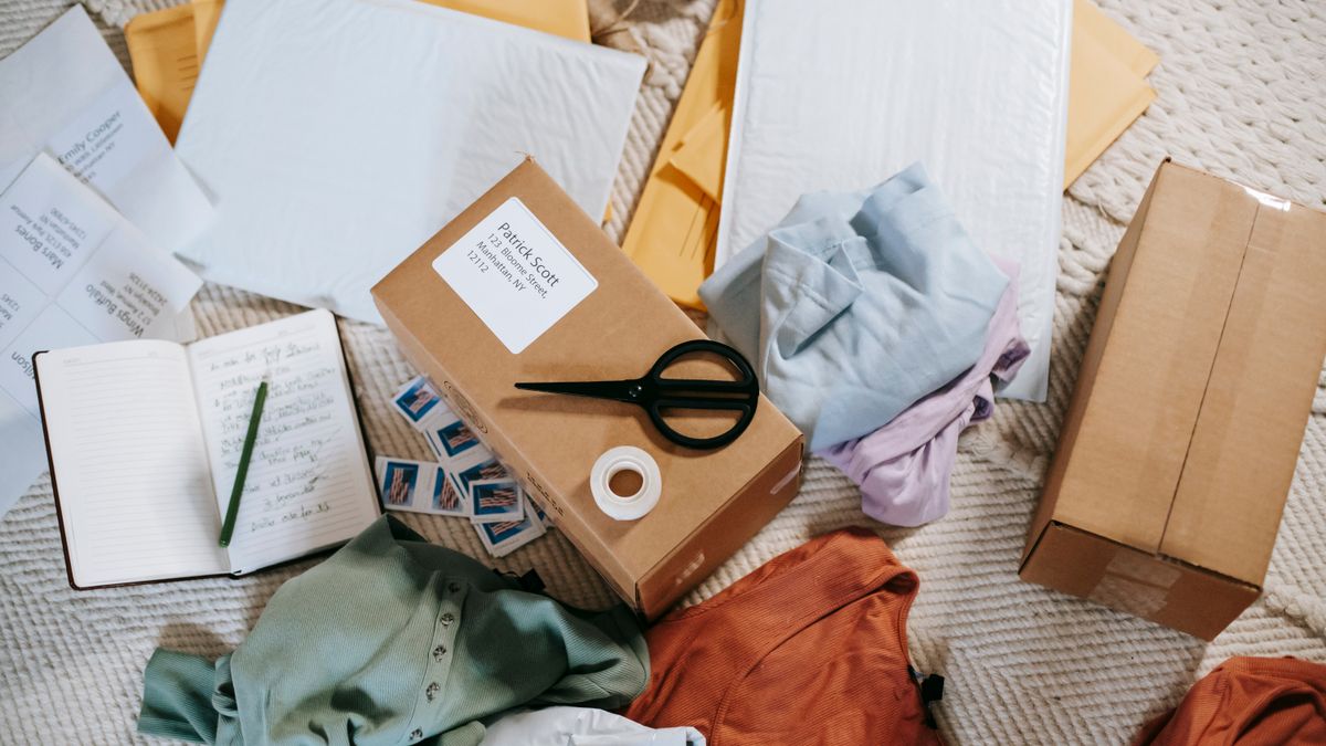 From above of various carton boxes and labels near clothes on surface in room